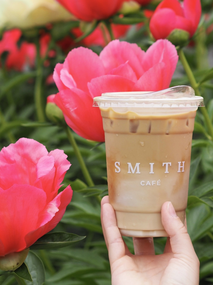 Café glacé de la Maison Smith présenté devant des fleurs rose